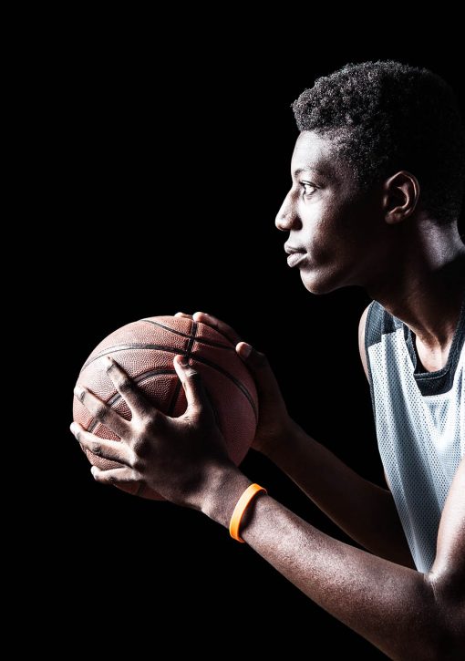 Young basketball player isolated on black background