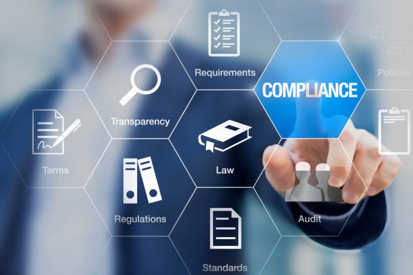 Compliance concept with icons for regulations, law, standards, requirements and audit on a virtual screen with a business person touching a button